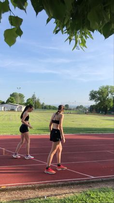 two women standing on a tennis court holding racquets