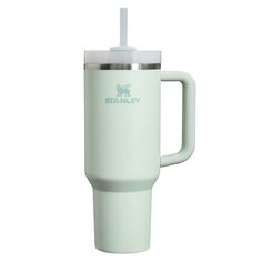 the stanley travel mug is light green and has a straw in it