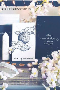 two greeting cards sitting on top of a wooden table next to flowers and candles with the words, the wandering factor