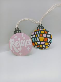 two ornaments with the words rejoice on them