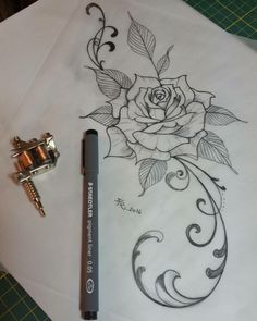 a rose tattoo is shown on a piece of paper with a pen next to it