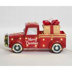 a red truck with christmas lights and presents on the back is shown in front of a white background