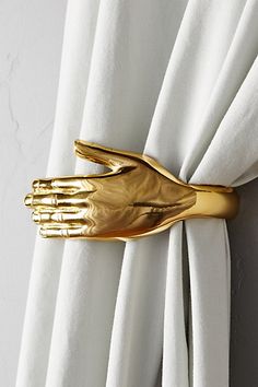 a gold hand is attached to the curtain