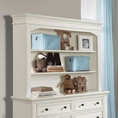 a white bookcase filled with books and stuffed animals