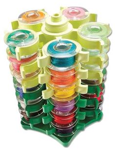 an assortment of different colored spools in a plastic holder on a white background