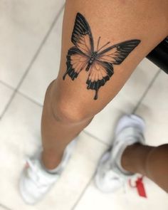 a woman's leg with a butterfly tattoo on it