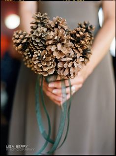 a woman holding a bouquet of pine cones