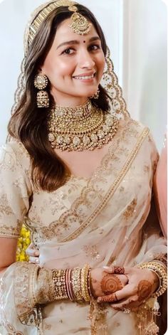 a woman wearing a bridal outfit and jewelry