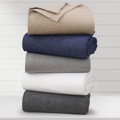 four folded sheets stacked on top of each other in various colors and sizes, with one folded