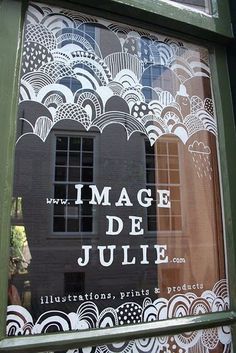 an image of a window that is decorated with black and white paper doillies