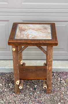 a small wooden table with glass top sitting on the ground next to a garage door