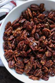 a white bowl filled with pecans on top of a table