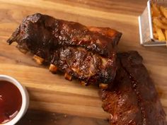 ribs and french fries on a cutting board with ketchup