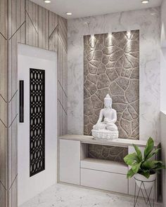 a white buddha statue sitting on top of a counter next to a plant in a vase