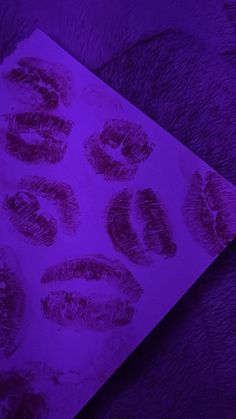 an image of some finger prints on a piece of paper with purple light in the background