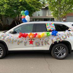 a white suv decorated with balloons and streamers