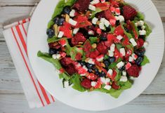 a white plate topped with a salad covered in veggies