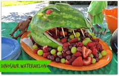 there is a watermelon shaped like a shark with fruit in it's mouth