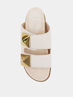 Experience the ultimate comfort and style with the BERNARDA slides by ShuShop. Featuring wide straps and molded footbeds, these sandals are crafted from smooth faux leather and adorned with oversized metallic studs. Elevate your warm-weather wardrobe with these, adding a touch of edgy sophistication to your outfits. Details cream slides wide double strap/not adjustable large gold studs molded footbeds faux leather brand: ShuShop Suede Jewelry, Nickel And Suede, Mothers Day Special, Skirt Jumpsuit, Beauty Sale, Wide Straps, Gold Studs, Sales Gifts, Warm Weather