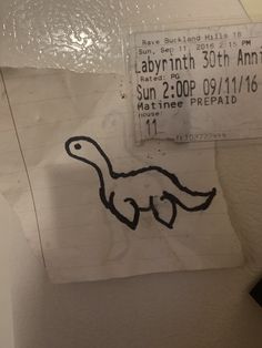 a piece of paper with a drawing of a dinosaur on it's left side