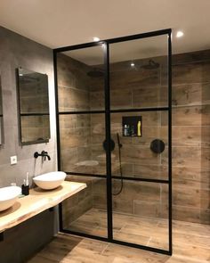 a bathroom with two sinks and a walk in shower next to a wooden counter top