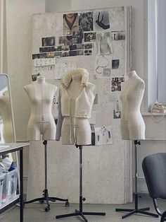 three mannequins are standing in front of a wall with pictures on it