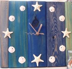 a clock made out of wooden boards with starfishs and seashells on them