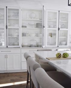 a kitchen with white cabinets and counter tops