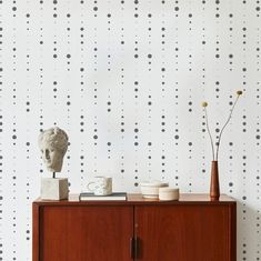 a wooden cabinet sitting next to a wall with dots on it