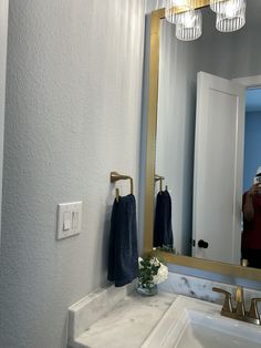 a bathroom with a sink, mirror and lights