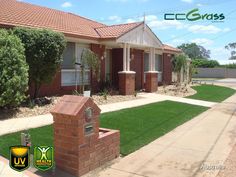 a brick house with green grass in the front yard