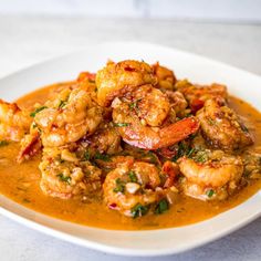 a white plate topped with shrimp and sauce