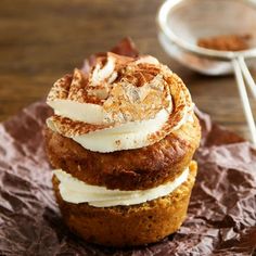 three cupcakes are stacked on top of each other with white frosting and cinnamon sprinkles