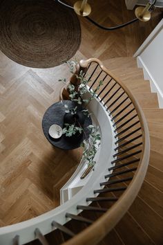 an overhead view of a spiral staircase with plants on the table in front of it