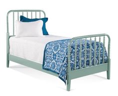 a bed with blue and white sheets on it's headboard, and pillows