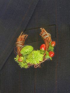 a man in a suit with a wreath made out of flowers and vegetables on his lapel