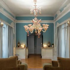 a living room filled with furniture and a chandelier