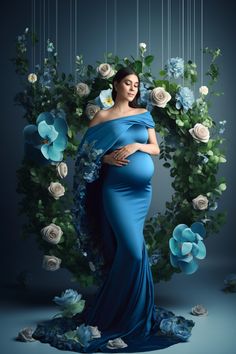 a pregnant woman in a blue gown with flowers around her