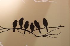 four birds are sitting on a branch in front of the light that is shining down