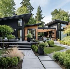 a modern house in the middle of a lush green yard with steps leading up to it