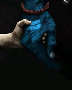 two hands holding each other with blue paint on their palms and the fingers are painted in different colors