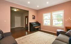 a living room with couches and a piano in it