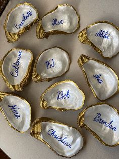 six oysters with names on them sitting on a table