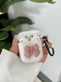 a person holding an apple airpods case with a pink bow