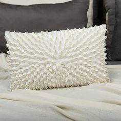 a white pillow sitting on top of a bed