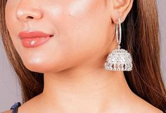 Make a bold fashion statement with our exquisite collection of American Diamond Jhumka earrings. Choose from a variety of styles, including the unique flair of Hoop Jhumka or the traditional charm of India Earrings. Add a touch of sparkle with CZ Jhumka or embrace the cultural richness of Bali Jhumka. Elevate your look with these stunning pieces and radiate elegance wherever you go. *𝐏𝐑𝐎𝐃𝐔𝐂𝐓 𝐃𝐄𝐓𝐀𝐈𝐋* * Material: Brass * Plating: White Rhodium Plated * Stone: AAA Quality CZ Diamond. * Elegant Danglers For Navratri, Navratri Bridal Earrings With Cutdana, Fusion Style Jhumkas For Diwali, Navratri Bridal Earrings, Chandbali Jhumkas For Eid, Round Tilla Jhumkas, Heavy Bridal Earrings For Festive Occasions, Eid Festival Chandbali Jhumkas, Bollywood Style Hoop Earrings With Cutdana