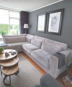 a living room filled with furniture and a table in front of a large window on top of a hard wood floor