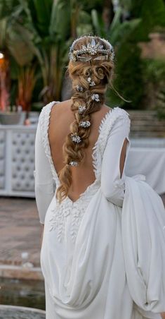 the back of a woman's wedding dress, with her hair in a braid