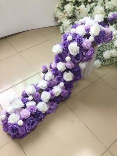 purple and white flowers are arranged on the floor