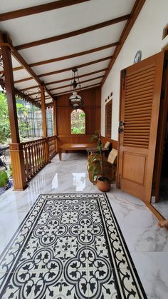 a large white and black rug on the floor in front of a wooden door with shutters